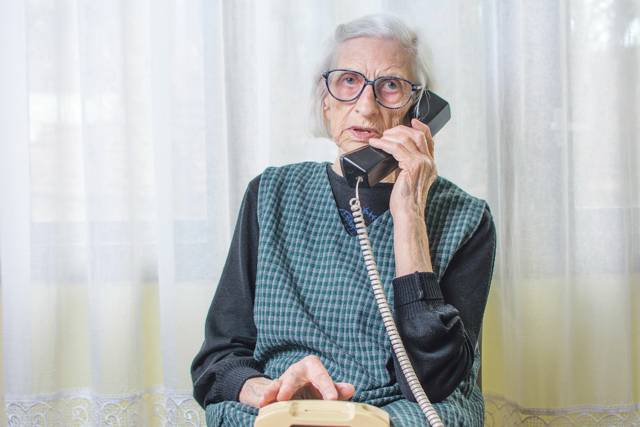 Eine ältere Dame mit einem Telefonhörer in der Hand