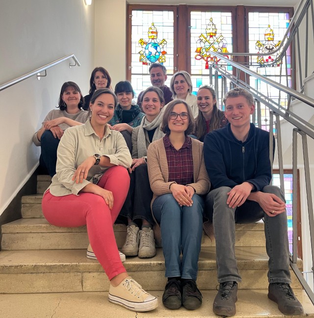 10 Personen die freundlich in die Kamera schauen