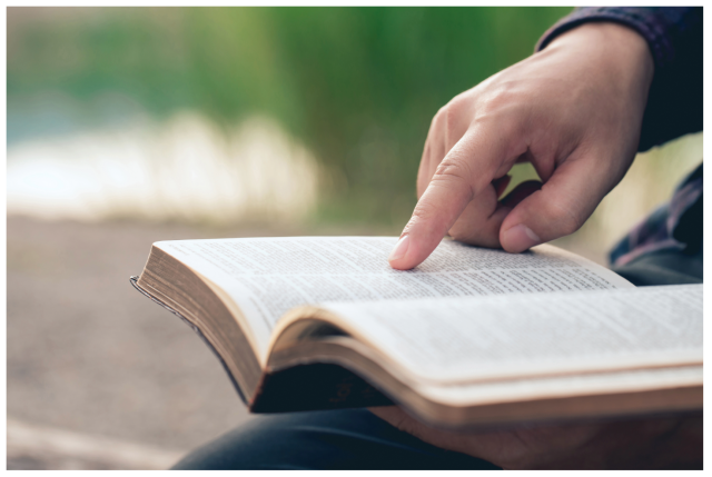 aufgeschlagenes Buch mit Hand